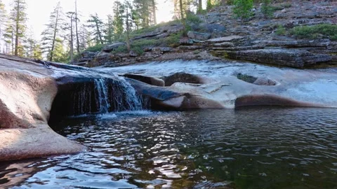 Small Cascade Waterfall Flowing into a Pool at Sunrise in the Sierra Nevada Stock Footage 317929077
