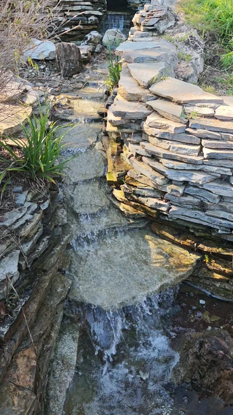Small Cascading Stream Flowing Through Decorative Rock Garden, 4K Stock Footage 339963858
