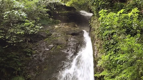 Small cascading waterfall with splashes in  rainforest Stockbeeldmateriaal 80673701
