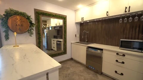 Small catering kitchen with white cabinets and hanging wine glasses Stock Footage 345553893