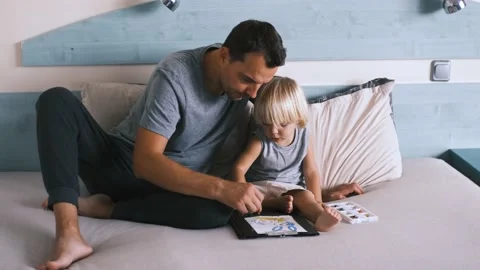 A small caucasian boy with his father on the bed draw with colored pencils. Stock Footage 220731845