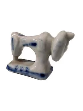 Small ceramic figurine of a sewing machine on a white clipping background Foto stock