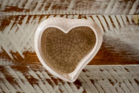 Small ceramic vase in heart shape with white and brown background Stock Photos