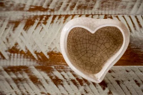 Small ceramic vase in heart shape with white and brown background Stock Photos
