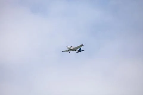 Small cessna 172 airplane soars through blue sky Stock Photos