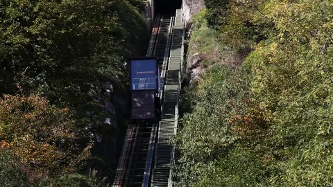 Small chain lift going down through forest from a castle entrance Stock Footage 119872669