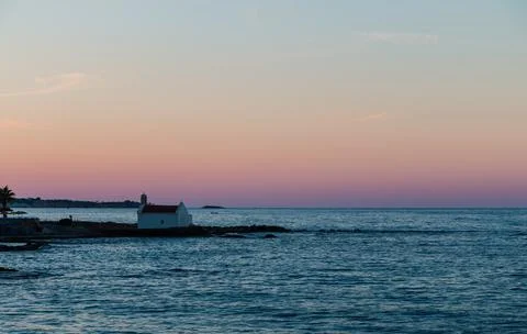 Small chapel against the backdrop of sunset on the sea, Crete Stock-Fotos