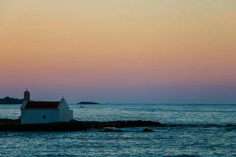 Small chapel against the backdrop of sunset on the sea, Crete Stock Photos