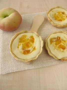 Small cheesecakes with peach Stock Photos