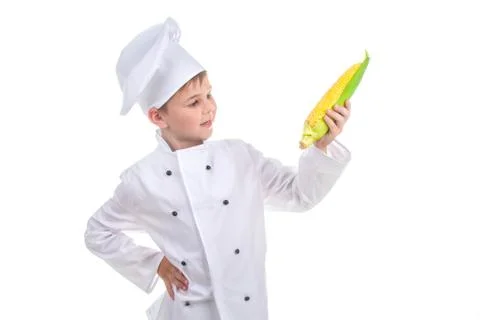 Small chef is looking at bright yellow fresh corn, isolated on white background Foto stock