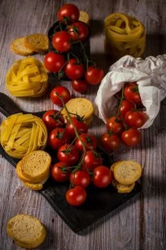 Small cherry tomatoes on several twigs with pasta Stock Photos