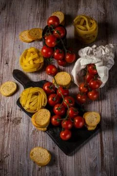 Small cherry tomatoes on several twigs with tagliatelle Stock Photos