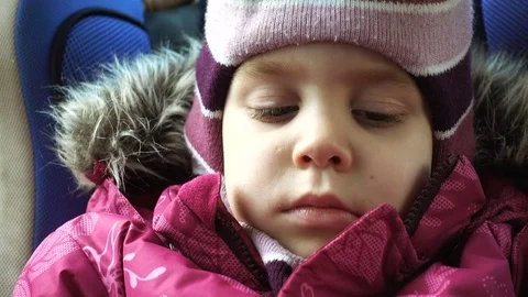 A small child 4-5 years of European or American appearance sits in a child se Stock Footage 84741991