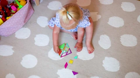 A small child is actively engaged in creative play, exploring colorful shapes Stock Footage 310522176