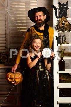 Small child and man ready for magic halloween night. Small child point at alarm Stock Photos