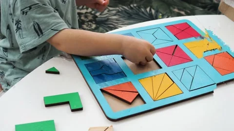 A small child assembles a wooden puzzle Stock-Footage 197595412