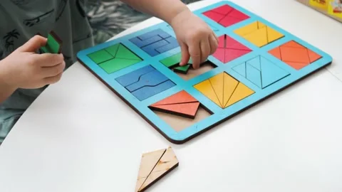 A small child assembles a wooden puzzle Stock Footage 197595450