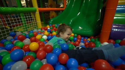 A small child / boy dressed in a turquoise t-shirt  slides down a Stock Footage 104028236