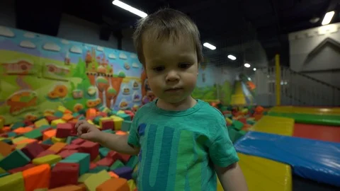 A small child / boy dressed in a turquoise t-shirt and blue pants stands in the Stock Footage 104028260