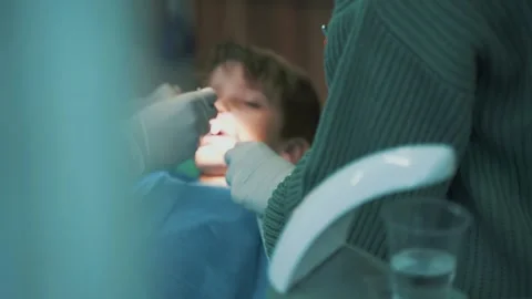 A small child boy kid in a dentist's chair treats teeth Stock Footage 259005789