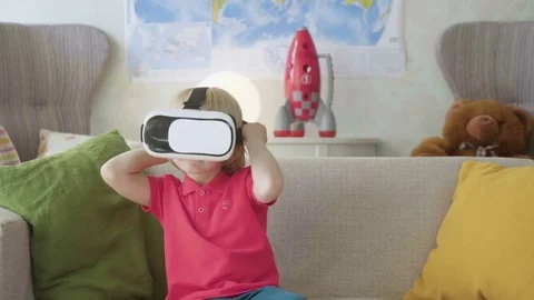 Small child boy play with VR glasses looking video being interested in and Stock Footage 77904825