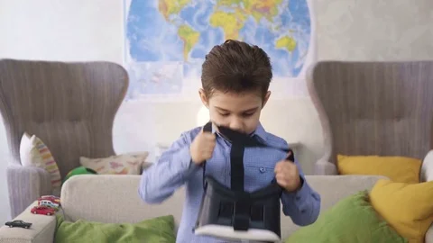 Small child boy play with VR glasses looking video being interested in and Stock Footage 78216424