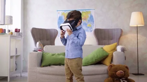 Small child boy play with VR glasses looking video being interested in and Stock Footage 78216433