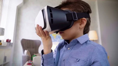 Small child boy play with VR glasses looking video being interested in and Stock Footage 78216501