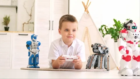 A small child boy plays with robots at home on a mat, a child learns to program Stock Footage 277385713