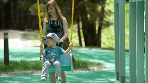 A small child, a boy sitting on a swing, Stock Footage 108736903