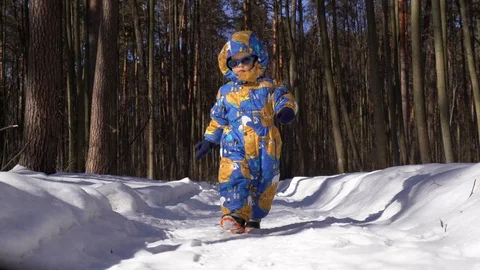 Small child / boy in winter overalls, hood and black sunglasses, Stock Footage 104028456