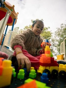 Small child building with vibrant blocks outdoors Fotos de archivo