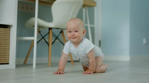 Small child crawls at home on all fours. Child learns about the world Stock Footage 303040185