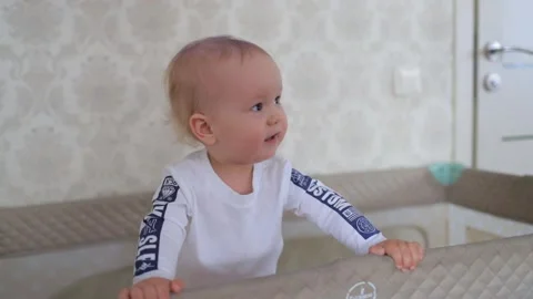 A small child dances in a crib Stock Footage 131643732