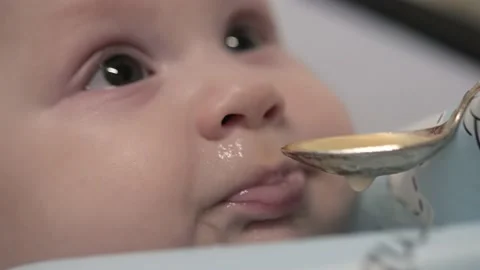 A small child does not want to eat with a spoon.Baby.Baby.Close - up of the face Stock Footage 169703394