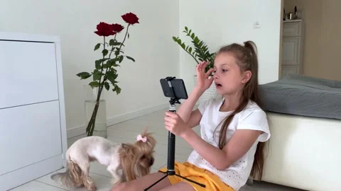 A small child with a dog in her arms is studying in a mobile phone Stock Footage 238819813