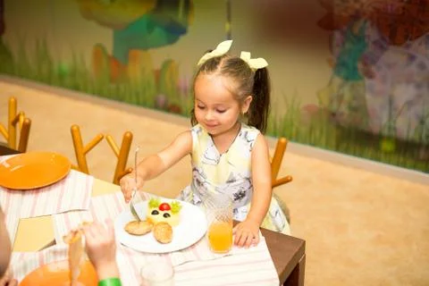 A small child, eating mashed potatoes with potatoes and cutlets in the form of Stock Photos