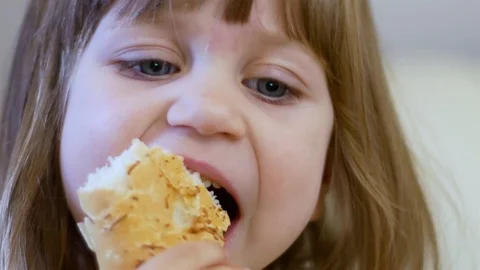 Small child eats bread behind Stock Footage 107676900