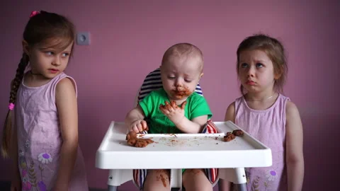 A small child eats chocolate. His face and hands are very dirty. The kid is Stock Footage 169158698