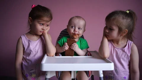 A small child eats chocolate. His face and hands are very dirty. The kid is Stock Footage 169158969