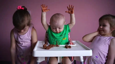 A small child eats chocolate. His face and hands are very dirty. The kid is Stock Footage 169159085