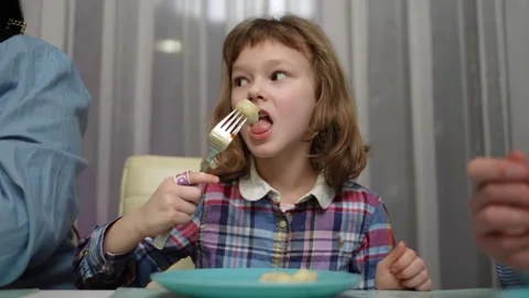 A small child eats dumplings with a fork Stock Footage 241301992