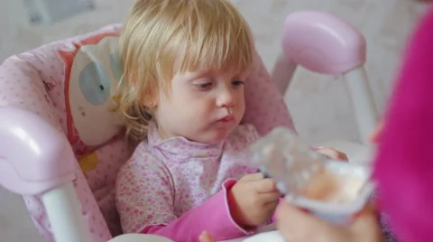 Small child eats food from a spoon Stock Footage 55442337