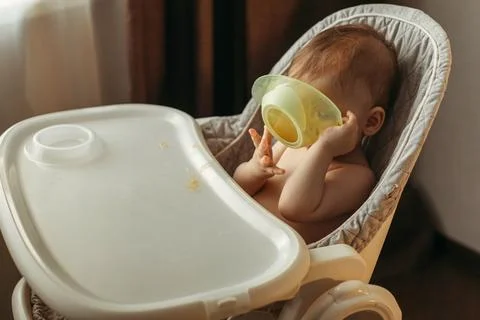 A small child eats vegetable puree without a spoon Stock Photos
