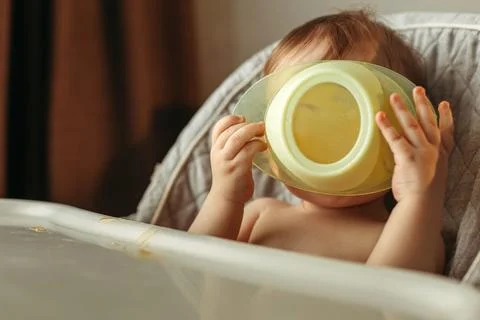 A small child eats vegetable puree without a spoon Stock Photos
