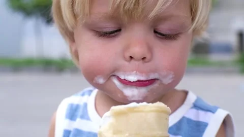 A small child eats white ice cream with great pleasure ice cream on face Stock-Footage 199214078