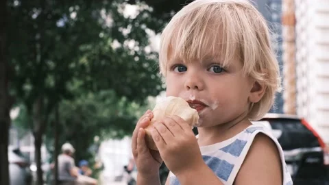 A small child eats white ice cream with great pleasure Video stock 199214416