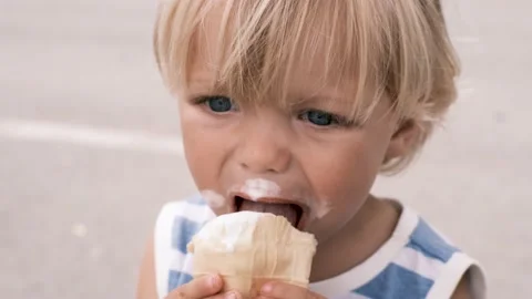 A small child eats white ice cream with great pleasure Stock Footage 199214506