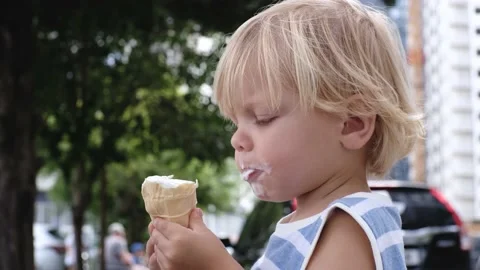 A small child eats white ice cream with great pleasure Stock Footage 199214847