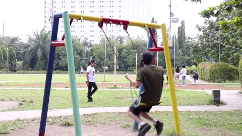 A small child enjoys playing on a swing by himself Stock-Footage 229593221